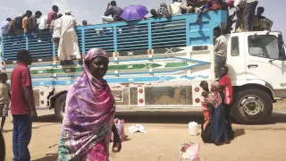 Personas suben a un camión a la salida de Jartum, Sudán