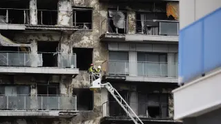 Bomberos trabajan en la limpieza del edificio incendiado en el barrio de Campanar