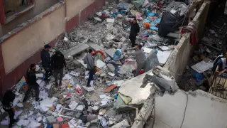 Palestinos buscan entre los restos de las viviendas tras un ataque israelí en la Franja de Gaza.
