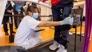 Una sanitaria instala el exoesqueleto de rodilla a una paciente del Hospital San Juan de Dios