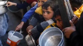 Niños palestinos esperan su ración de comida en Rafah, al sur de Gaza