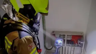 Un bombero revisa el cuadro eléctrico donde se ha originado el humo.