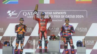 Podio del Gran Premio de Qatar: Francesco Bagnaia del equipo Ducati Lenovo (centro), el segundo clasificado el sudafricano Brad Binder del Red Bull KTM Factory Racing, a la izquierda, y el tercer clasificado, el piloto español Jorge Martín del Prima Prama