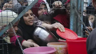 Centenares de palestinos hacen cola para recibir comida en la Franja de Gaza.