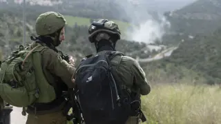 Dos soldados israelíes participan en la operación de búsqueda de un atacante palestino después de que disparara contra un minibús en el centro de Cisjordania ocupada e hiriera a al menos siete personas, la mayoría soldados, lo que derivó en enfrentamientos de varias horas durante la búsqueda del sospechoso, que fue finalmente abatido por un helicóptero de combate israelí.