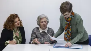 Mónica Caballero, Teresita Almagro y Mª Jesús Buey consultan la documentación que han recopilado para sustentar su reivindicación