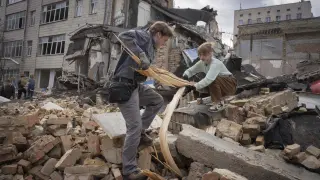 Voluntarios estudiantes ayudan en las labores de desescombro tras un ataque ruso en Kieve, este sábado.