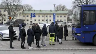 Agentes de policía acompañan a familiares de los alumnos de la escuela Viertola, en Vantaa (Finlandia) tras el tiroteo.