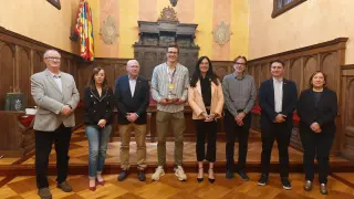 Christian Iguacel posa junto a la alcaldesa Lorena Orduna y otras autoridades en el Salón del Justicia del Ayuntamiento de Huesca.