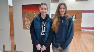Las estudiantes ucranianas Arina Karamalikova y Sofía Voloshyna, junto a las obras que han expuesto, en el Colegio Británico de Zaragoza del que son alumnas.