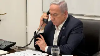 El primer ministro israelí Benjamin Netanyahu atiende una llamada en su despacho.