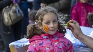 A una niña le pintan la bandera de Aragón en el rostro en una de las actividades que llenaron este lunes por la tarde el Pignatelli