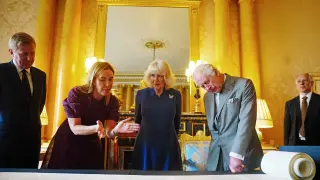 El rey Carlos III y la reina Camila contemplan el Rollo de la Coronación en Buckingham Palace