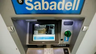 FILE PHOTO: Sabadell bank's logo is seen at an ATM machine outside an office in Barcelona, Spain