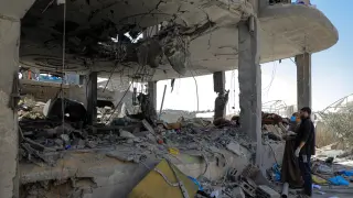 Personas inspeccionan un edificio destruido tras un ataque aéreo israelí en la ciudad de Rafá, en el sur de la Franja de Gaza.