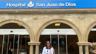 Darling Montoya, responsable del proyecto de Voluntario Domiciliario, frente al San Juan de Dios, con la guía sobre la soledad no deseada.