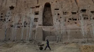 FILE PHOTO: An Afghan man works in front of the ruins of a 1500-year-old Buddha statue in Bamiyan