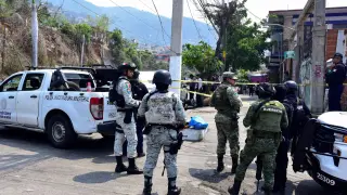 Fuerzas de seguridad custodian la escena del crimen donde agresores desconocidos dejaron los cuerpos desmembrados de Aníbal Zúñiga Cortés, candidato a concejal del municipio de Coyuca de Benítez por el centrista Partido Revolucionario Institucional (PRI), y su esposa, en Acapulco