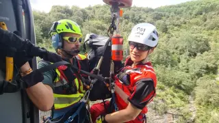 Nuria Gago, junto a un componente del Greim, colgada de la grúa del helicóptero en un rescate.
