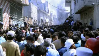 Una multitud reunida en el lugar de los hechos, después de que una turba violenta atacara a una comunidad cristiana por presunta blasfemia en Sargodha, Pakistán.