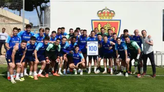 Fran Gámez posa junto al resto de compañeros con el cuadro de sus 100 partidos en el Real Zaragoza.