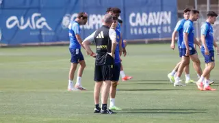 Víctor Fernández charla a solas con Alejandro Francés este miércoles durante el entrenamiento del Real Zaragoza. En segundo plano, Azón se ha dado cuenta de la cuestión y mira con interés.