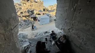Palestinos entre los restos de su vivienda destruida en un ataque israelí en Khan Younis, en la Franja de Gaza.