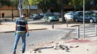 Efectivos de la Policía científica inspeccionan el lugar donde se ha producido el tiroteo en el barrio de las Tres mil viviendas en Sevilla.