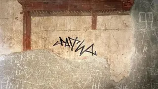Firma con rotulador permanente en la pared de una antigua casa en Herculano