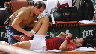Novak Djokovic recibe asistencia médica durante el partido con el argentino Francisco Cerúndolo en Roland Garros