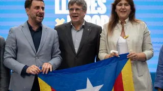 El expresidente de la Generalitat, Carles Puigdemont; el cabeza de lista de Junts, Toni Comín (i), y la expresidenta del Parlament, Laura Borrás, durante el acto de campaña de JxCat para las elecciones europeas celebrado este viernes en Colliure (Francia).