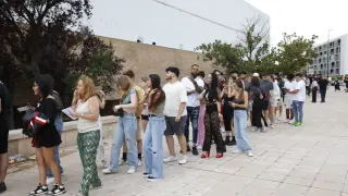 Filas de personas aguardan para entrar al concierto de Eladio Carrión en el pabellón Príncipe Felipe, en Zaragoza