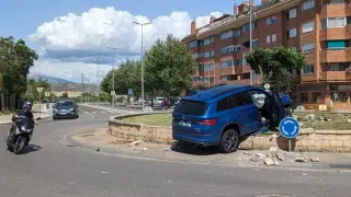 Imagen del coche subido al muro de la rotonda de la avenida Doctor Artero de Huesca.
