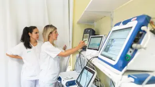 Las enfermeras Rebeca García y Laura Sorinas, con los equipos que controlan los dispositivos.