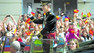 Don Felipe, convertido en Rey, saluda junto a la reina Letizia a quienes aquel 19 de junio de 2014 se echaron a las calles de Madrid para aclamarle