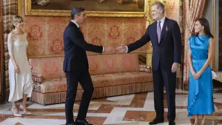 El rey Felipe VI (2d) y la reina Letizia (d) saludan al presidente del Gobierno, Pedro Sánchez (2i), y a su mujer Begoña Gómez (i) durante el besamanos en el Palacio Real en Madrid donde se conmemora el décimo aniversario del reinado de Felipe VI
