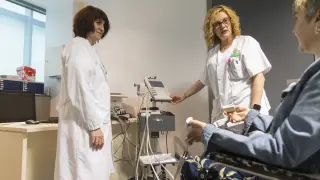 Dos profesionales sanitarias atienden a una paciente en la Unidad de Enfermedades Neuromusculares de Aragón, ubicada en el Inocencio Jiménez.