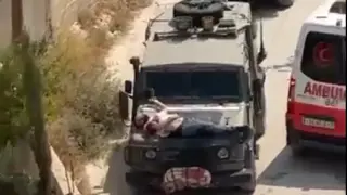 Imagen del palestino herido sobre un vehículo militar israelí