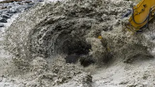 Una máquina excavadora trabaja en la zona afectada en la localidad de Chippis