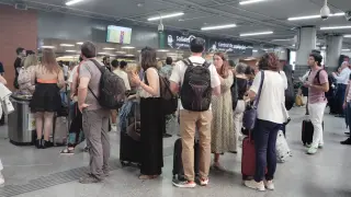 Viajeros afectados por el corte de la línea Madrid-Barcelona, a la espera en la estación de Atocha, este jueves por la tarde.