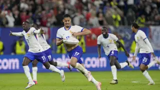 Theo Hernandez celebra con sus compañeros el gol en el último penalti en el partido