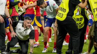 Spain's Alvaro Morata, centre, holds his leg after an incident with an invader after a semifinal match between Spain and France at the Euro 2024 soccer tournament in Munich, Germany, Tuesday, July 9, 2024. Left Spain's Rodri. (AP Photo/Hassan Ammar)