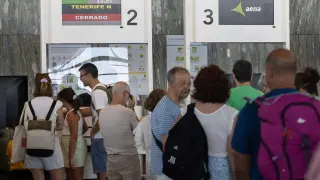 Pasajeros del vuelo a Tenerife esperan su turno en la fila para facturar.