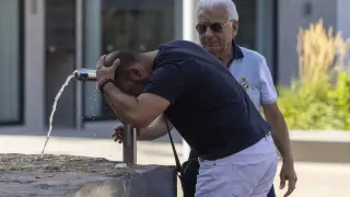 Un hombre se refresca este sábado en la fuente de la plaza de Salamero de Zaragoza.