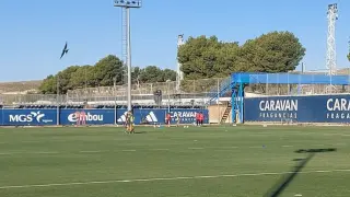 Los tres porteros que han entrenador este lunes con el Real Zaragoza, Femenías, Poussin y el juvenil Olmos, en la lejanía del rincón más lejano a la zona de prensa en la Ciudad Deportiva.
