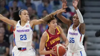 Mariona Ortiz, of Spain, gets trapped between Trinity San Antonio and Jacqueline Benitez, of Puerto Rico, in a women's basketball game at the 2024 Summer Olympics, Wednesday, July 31, 2024, in Villeneuve-d'Ascq, France. (AP Photo/Mark J. Terrill)