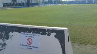 Uno de los diversos carteles colocados en los graderíos del campo central del Pinatar Arena murciano donde se juegan los partidos y en el que se prohíbe quedarse con el torso desnudo a los espectadores.