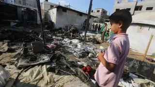 Un niño palestino junto a una escuela derribada