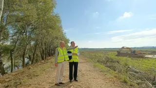 El director del Instituto Aragonés del Agua, Luis Estaún, y el consejero de Medio Ambiente, Manuel Blasco, este jueves, en la mota que se va a retranquear en Osera.
