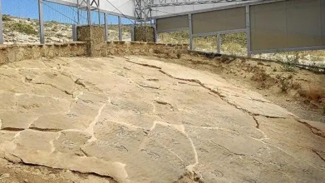 El contorno de las huellas fósiles de dinosaurio de Las Cerradicas, marcado con líneas blancas y negras.